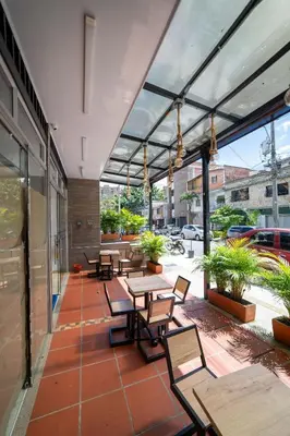 a patio with tables and chairs on a building at Hotel Doxa in Medellín