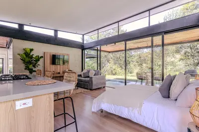 a bedroom with a bed and a kitchen with a table at Soy Local Reserva Sajonia in Rionegro