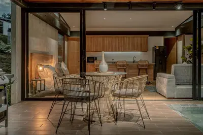 a patio with a table and chairs and a living room at Soy Local Reserva Sajonia in Rionegro