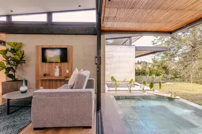 a house with a swimming pool with a couch and a tv at Soy Local Reserva Sajonia in Rionegro