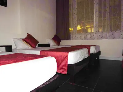a hotel room with two beds and a window at Hotel San Marcos in Manizales