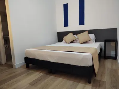 a bed with two pillows on it in a room at Hotel San Marcos in Manizales