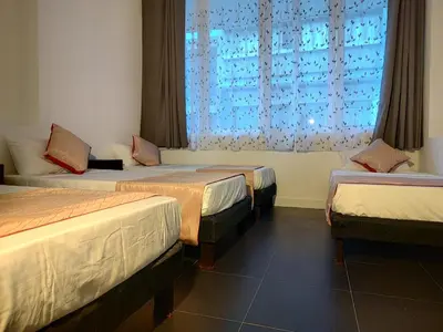a room with three beds and a window at Hotel San Marcos in Manizales