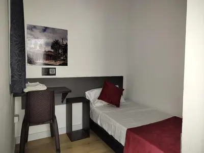 a small room with a bed and a table and a chair at Hotel San Marcos in Manizales