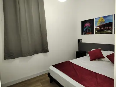 a bedroom with a white bed with red pillows at Hotel San Marcos in Manizales