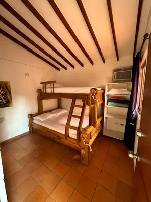 a room with two bunk beds and a refrigerator at Cabaña ciudadela del sol in San Jerónimo