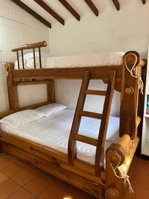 two bunk beds in a room with a ladder at Cabaña ciudadela del sol in San Jerónimo