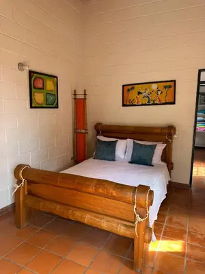 a bedroom with a wooden bed and a wooden bench at Cabaña ciudadela del sol in San Jerónimo