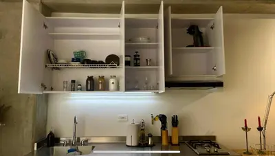 a kitchen counter with white cabinets and a sink at Loft con Patio privado in Medellín