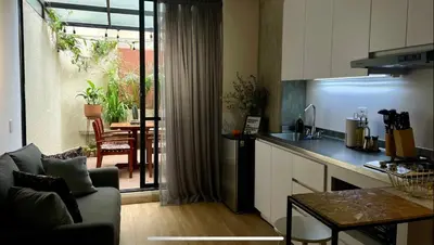 a kitchen and living room with a couch and a table at Loft con Patio privado in Medellín