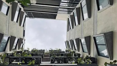a courtyard with tables and plants in a building at Loft con Patio privado in Medellín