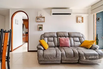 a brown couch with colorful pillows sitting in a living room at City views Air-conditioning Heated pool in Envigado