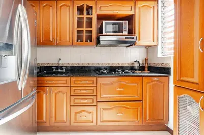 a kitchen with wooden cabinets and a microwave at City views Air-conditioning Heated pool in Envigado