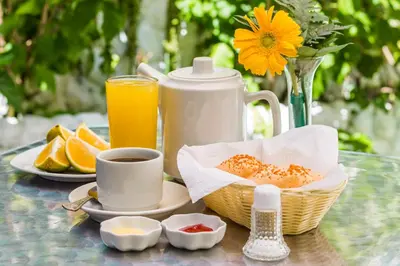 a table with a cup of coffee and a basket of food at Victoria Imperial Hotel in Mariquita