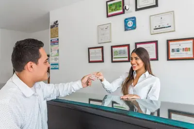 a man and a woman at a cash register at Victoria Imperial Hotel in Mariquita