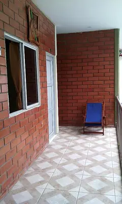 a blue chair sitting next to a brick wall at Victoria Imperial Hotel in Mariquita