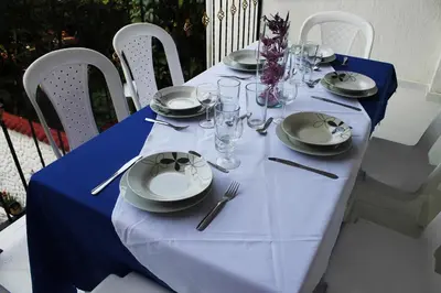 a table with a blue table cloth and plates and silverware at Victoria Imperial Hotel in Mariquita