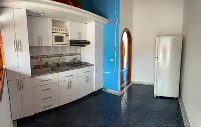 a kitchen with white cabinets and a refrigerator at Casa grande parque central in San Rafael