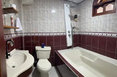 a bathroom with a toilet and a tub and a sink at Casa grande parque central in San Rafael