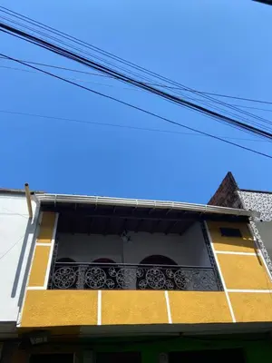 a yellow and white building with a balcony at Casa grande parque central in San Rafael