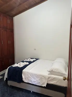 a bedroom with a bed with white sheets and pillows at Casa grande parque central in San Rafael