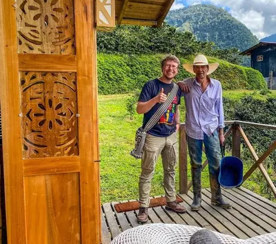two men are standing on a wooden deck at Finca Milena Jardin Antioquía in La Morelia