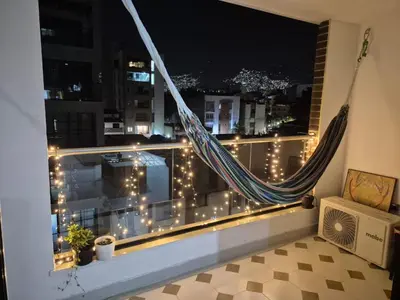 a hammock in a window with a view of a city at Apartamento Luareles-San joaquin-Balcon in Medellín