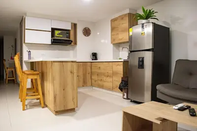 a kitchen with a stainless steel refrigerator and a table at Apartamento Luareles-San joaquin-Balcon in Medellín