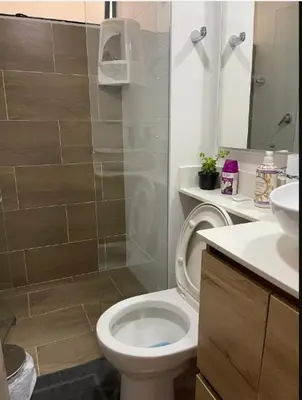 a bathroom with a white toilet and a shower at Apartamento Luareles-San joaquin-Balcon in Medellín