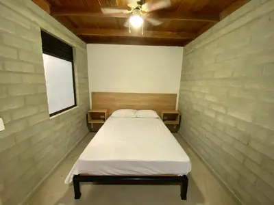 a bedroom with a bed in a brick wall at Hospedaje San Diego in Medellín