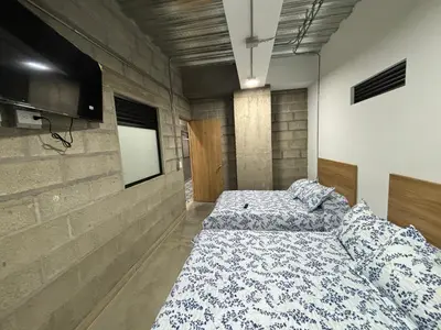 a bedroom with two beds and a flat screen tv at Hospedaje San Diego in Medellín