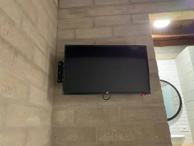 a flat screen tv hanging on a stone wall at Hospedaje San Diego in Medellín