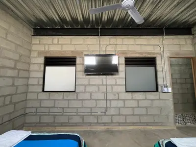 a brick wall with three windows and a tv at Hospedaje San Diego in Medellín