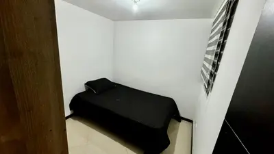 a small room with a black bed in a white wall at Rodeo Alto in Belén