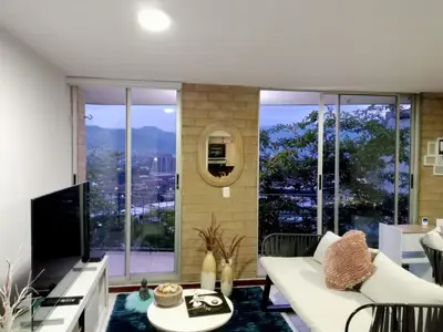 a living room with a white couch and a large window at Apartment in Poblado - Medellín in Medellín