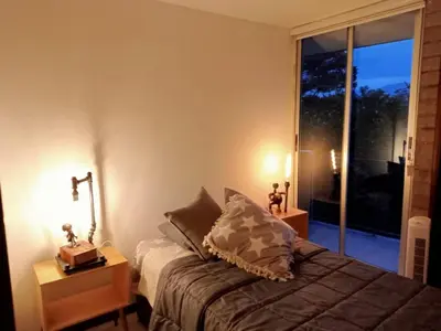 a bedroom with a bed and a large window at Apartment in Poblado - Medellín in Medellín