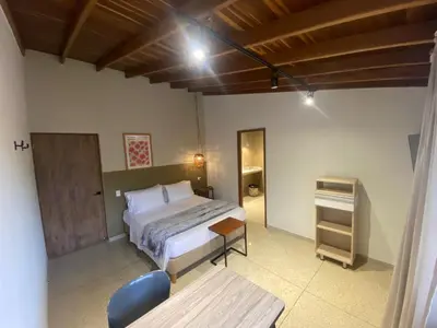 a bedroom with a bed and a table in it at Hotel La Vega in Concepción