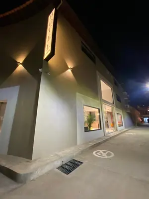 a white building with a sign on the side of it at Hotel La Vega in Concepción