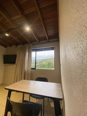 a table and chairs in a room with a window at Hotel La Vega in Concepción