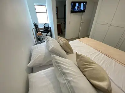 two beds with pillows and a television in a room at laureles excelente ubicacion la 70 estadio, cerca al poblado in Medellín