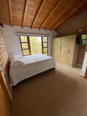 a bedroom with a bed and a large window at Habitación con baño privado en casa de campo ubicada en Santa Elena in Santa Elena