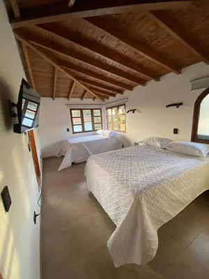 a bedroom with two beds in a room with wooden ceilings at Habitación con baño privado en casa de campo ubicada en Santa Elena in Santa Elena