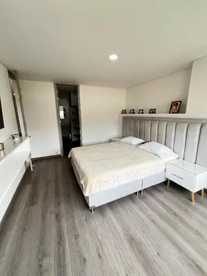 a bedroom with a large bed and a wooden floor at Modern 3 Bedroom Apartment with balcony in Medellín