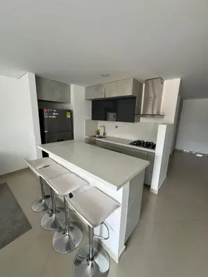 a kitchen with a counter and two stools in it at Modern 3 Bedroom Apartment with balcony in Medellín