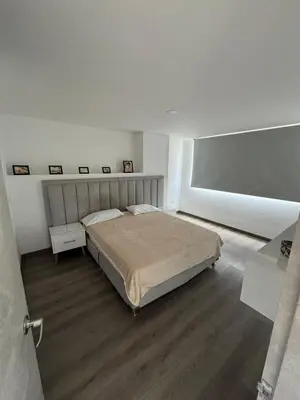 a white bedroom with a bed and a wooden floor at Modern 3 Bedroom Apartment with balcony in Medellín