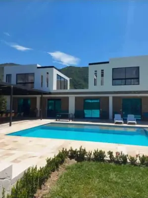 a large house with a swimming pool in front of it at Finca en sopetrán in Sopetran