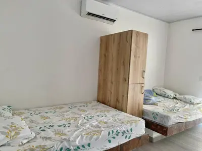 a bedroom with two beds and a wooden cabinet at Finca en sopetrán in Sopetran