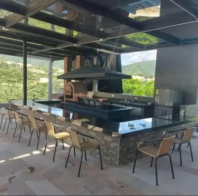 a patio with a bar with chairs and a grill at Finca en sopetrán in Sopetran