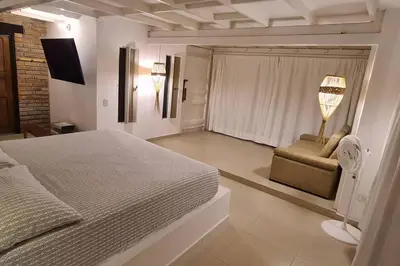 a bedroom with a bed and a chair and a fan at TerraMonte in Honda
