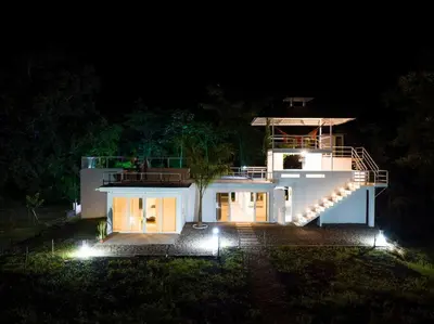 a large white house with a staircase at night at TerraMonte in Honda